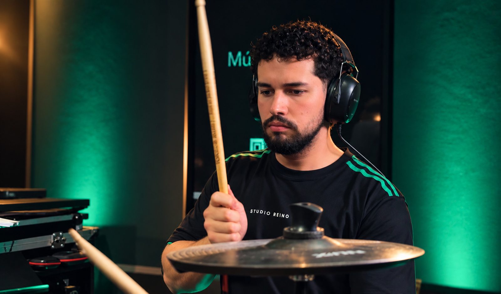 Baterista com fones de ouvido tocando no Studio Reino Musical